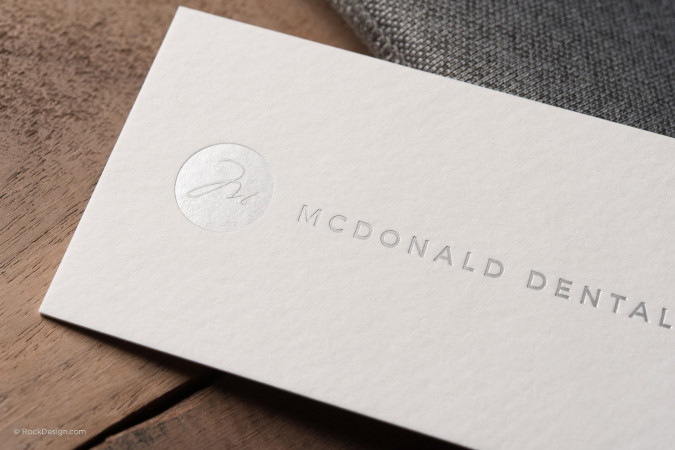 Modern minimalist textured cream business card with silver foil - McDonald Dental