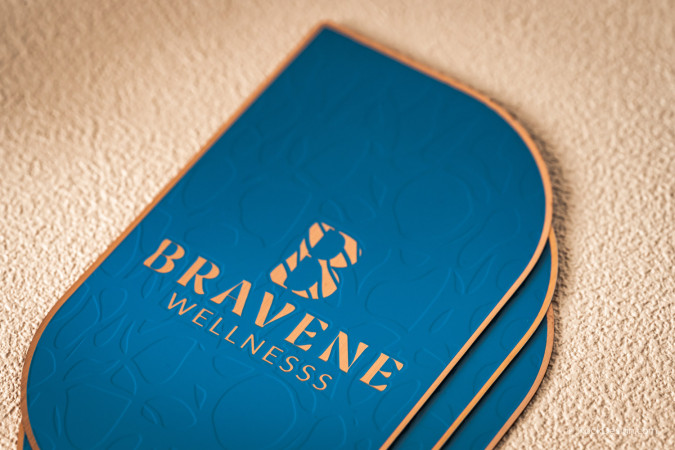 Close-up of blue and copper metal business card with etched texture and luxury spot color logo for Bravene Wellness