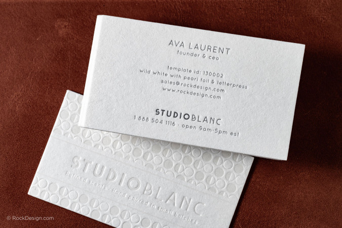 Close-up of luxury letterpress business card design on wild white cotton paper with pearl foil stamping and textured pattern for Studio Blanc branding.