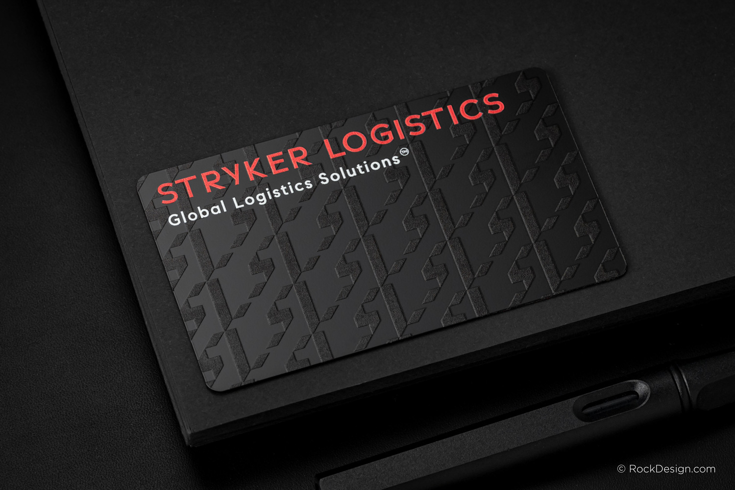 Premium black metal business card for Stryker Logistics with red logo, UV gloss pattern, and sleek typography — luxury print finish by RockDesign.