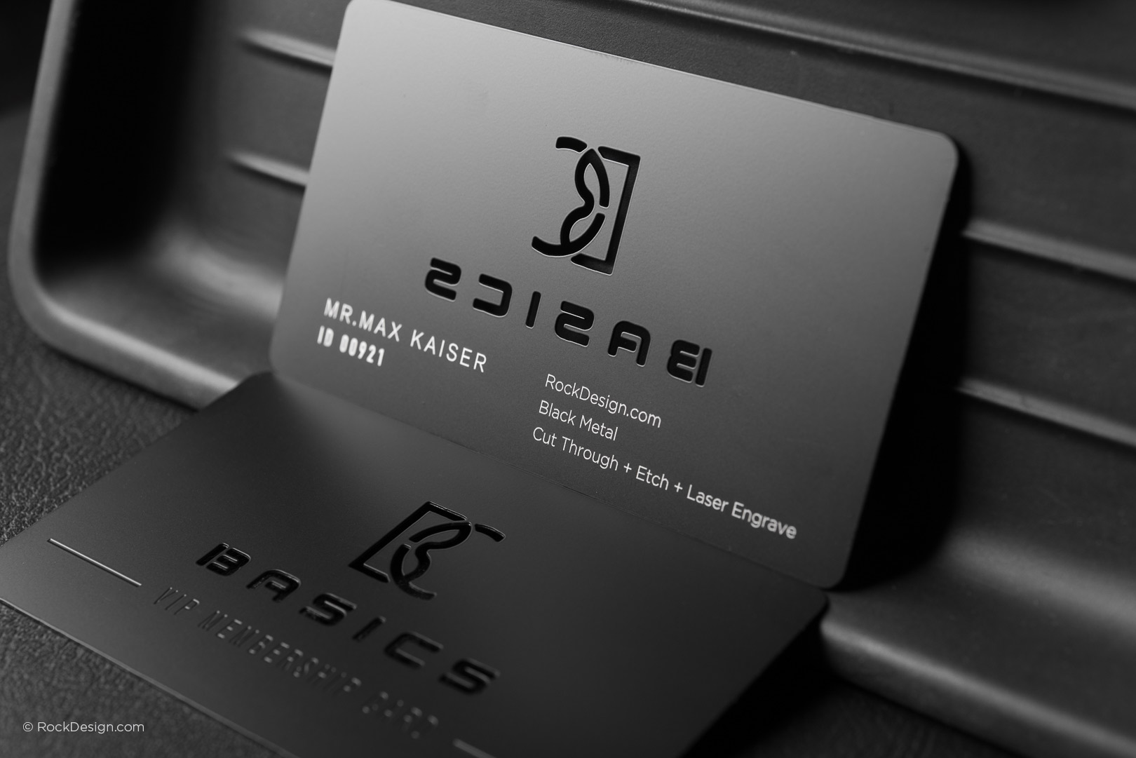 Two black metal VIP cards with custom laser engraving and cut-through logo by RockDesign